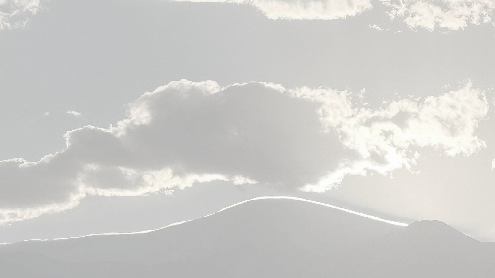Cielo nublado sobre la cordillera; una línea de luz recorre la cresta