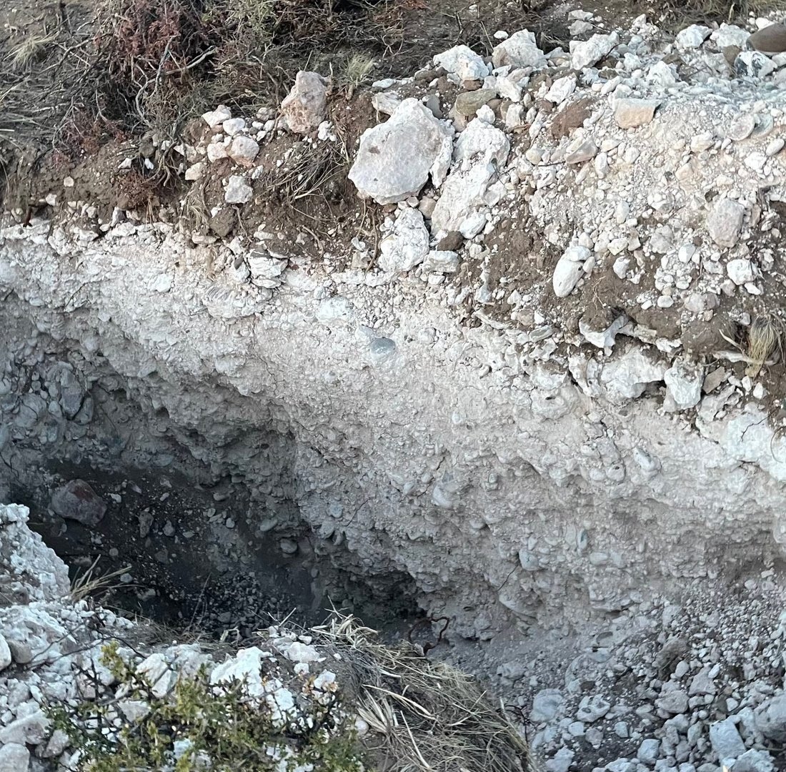 Corte de suelo: piedra y capas blancas de carbonato de calcio